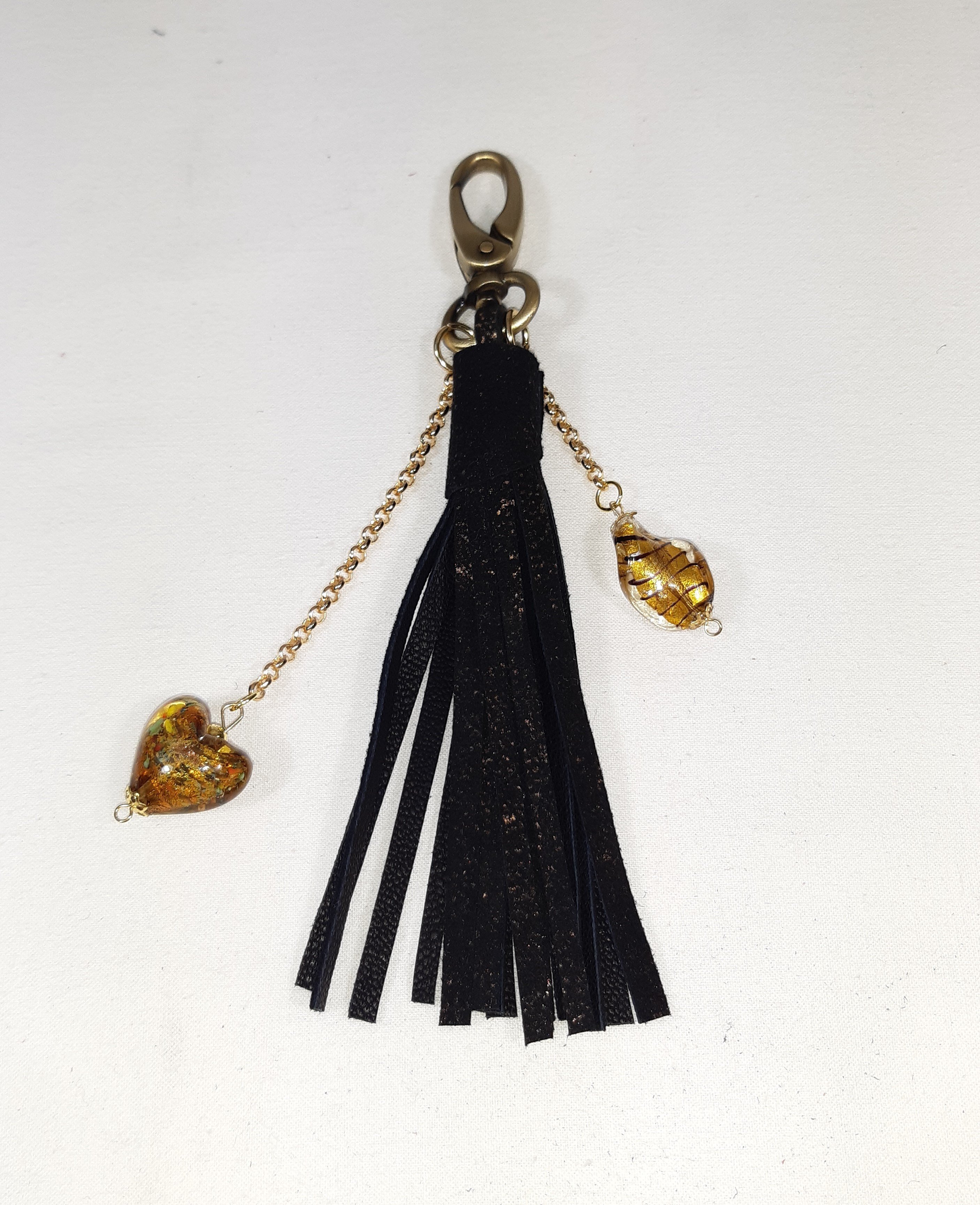 Bijou de sac, pompon cuir coloris noir et or avec coeur verre de Murano.