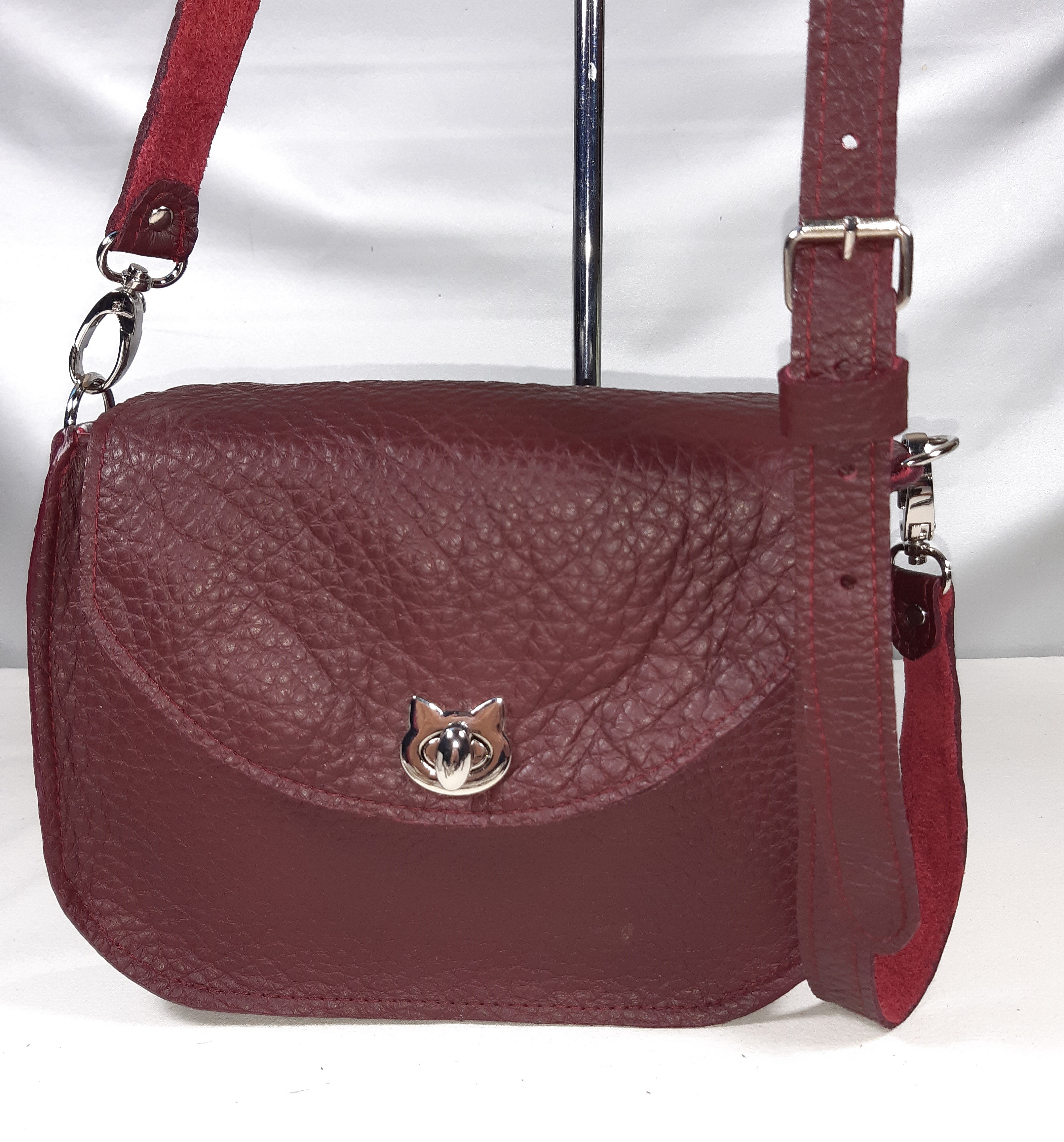 Sac bandoulière bordeaux en cuir avec fermoir chat argenté.